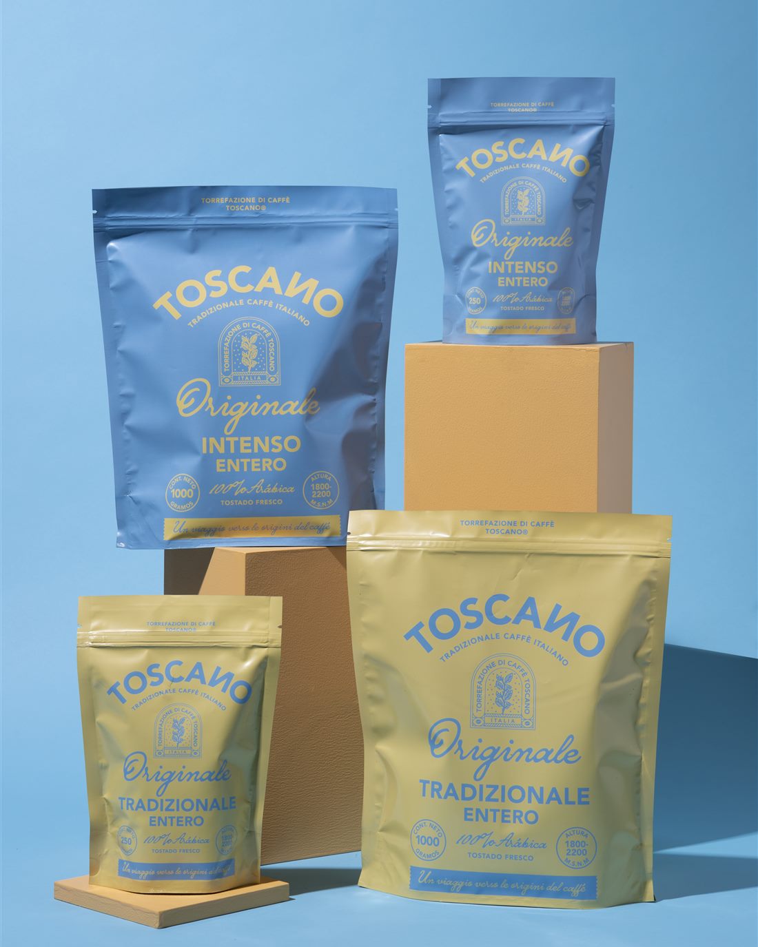 Bolsas de Café Toscano Intenso y Tradizionale apiladas sobre fondo azul